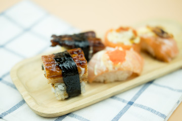 Various kinds of sushi served on wooden tray