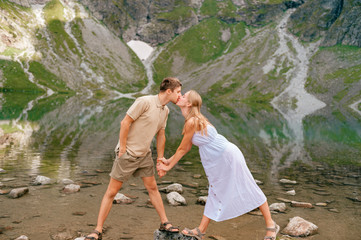 Naklejka premium Expressive couple having fun in black lake (Czarny Staw) under Mount Rysy in High Tatra national park.