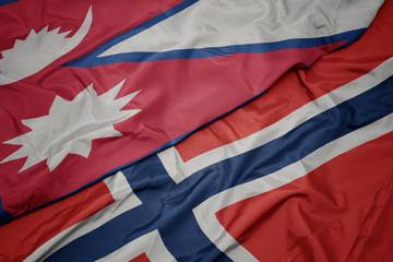 waving colorful flag of norway and national flag of nepal.