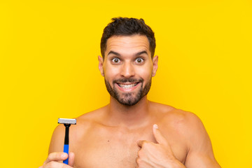 Fototapeta premium Man shaving his beard with surprise facial expression