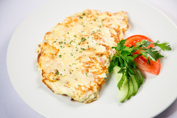 fried eggs and omelet with vegetables on a white background