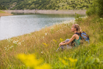 Fototapeta na wymiar Woman hiker enjoys sitting in the beautiful nature.