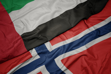 waving colorful flag of norway and national flag of united arab emirates.