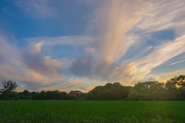 Wieczór panorama z pola chmury oświetlone zachodem słońca zieleń