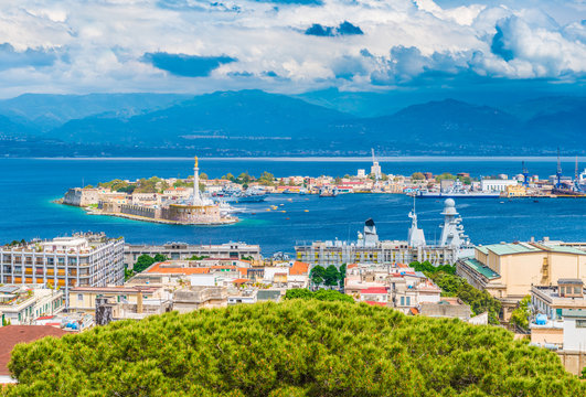 Beautiful panorama of Messina port with blue mountains in the background. It is written on the seawall in Latin "Vos Et Ipsam Civitatem Benedicimus (I Bless You And Your City), Sicily, Italy