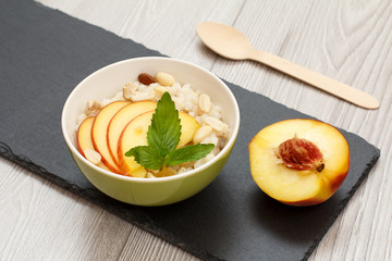 Sorghum salad with nuts and fresh peach on gray boards