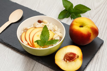 Sorghum salad with nuts and fresh peach on stone board.