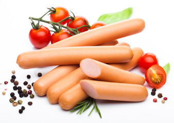 Classic boiled meat pork sausages with pepper and basil and cherry tomatoes on white background.
