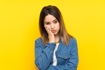 Fototapeta na wymiar Young woman over yellow background unhappy and frustrated