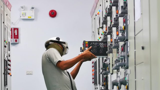 Maintenance Technician to check electrical device in Electricity substation building in industrial plant. Industrial and technology concept