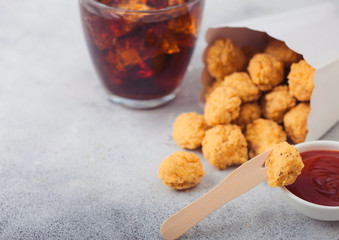 Crunchy southern chicken popcorn bites in white paper container for fast food meals with ketchup...