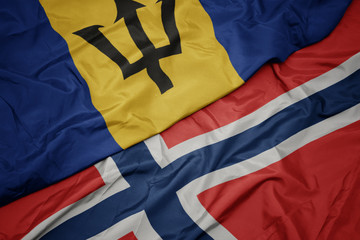 Fototapeta premium waving colorful flag of norway and national flag of barbados.