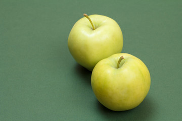 Green apples on green background with copy space.
