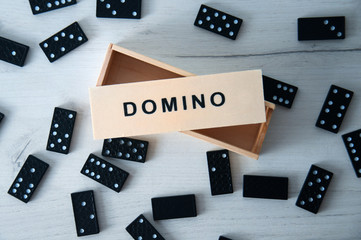Closeup scattered dominoes on a gray, wooden table. Board game.