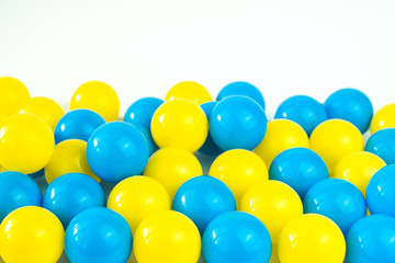 Fototapeta na wymiar .Yellow and blue plastic balls in pool of game room. Dry Swimming pool for fun and jumping in colored plastic balls. The concept of celebration and fun.