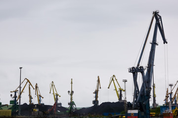 In freight terminal, gantry crane and cargo ships are in loading and unloading of goods