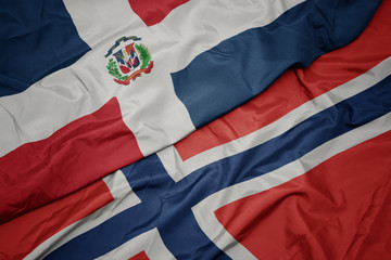 Fototapeta premium waving colorful flag of norway and national flag of dominican republic.