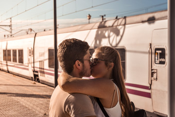 Young couple kiss passionately to say goodbye before their trip.