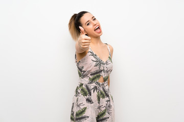Young woman over isolated white background with thumbs up because something good has happened