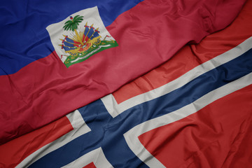 waving colorful flag of norway and national flag of haiti.