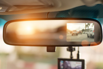 Close up car on highway at sunset, with video recorder next to a rear view mirror,video recorder...