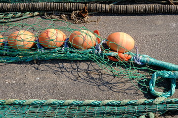 Colourful fishing floats, ropes and nets on a jetty