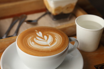  cup of hot coffee latte art with tulip pattern on wooden table in cafe with copy space