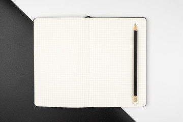 Top view of an emptry grid notebook with pencil
