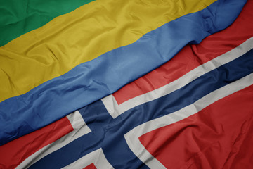 waving colorful flag of norway and national flag of gabon.