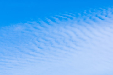 The vivid sky or heaven background with white and blue Cirrus and layered clouds under the sun rays