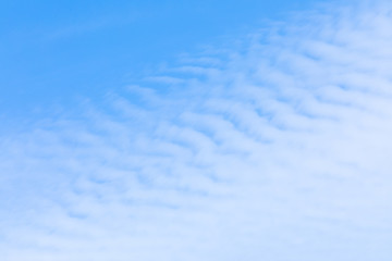 The vivid sky or heaven background with white and blue Cirrus and layered clouds under the sun rays