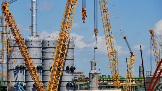 Under construction of Refinery tower and production area in oil and gas petroleum plant with vertical heavy crane
