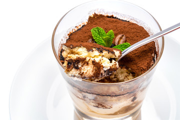 Classic tiramisu dessert in a glass cup on the plate on white background with clipping path