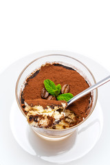 Classic tiramisu dessert in a glass cup on the plate on white background with clipping path