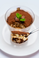 Spoon full of Classic tiramisu dessert on white background with clipping path