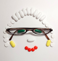 Fototapeta na wymiar Woman with glasses laid out from pills and capsules. Top view.