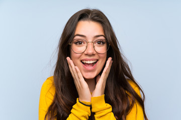 Teenager girl over isolated blue wall with surprise facial expression