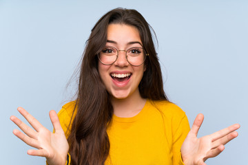 Teenager girl over isolated blue wall unhappy and frustrated with something