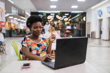 Beautiful Young Dark Skinned Freelancer Woman Using Laptop Computer Sitting At Cafe Table. ...