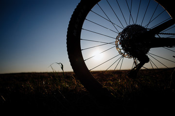 Silhouette of the bikecycle against the blue sky at sunset