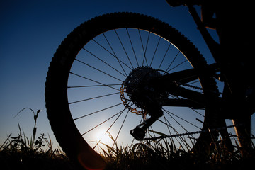 Silhouette of the bikecycle against the blue sky at sunset