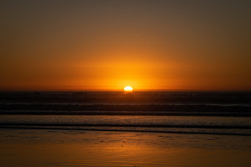 Obraz na płótnie Canvas Last sunlight of the day with sunset over the Atlantic Ocean from Agadir beach, Morocco, Africa