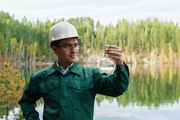 industrial ecologist visually evaluates the response of a water sample from lake at the site of a...