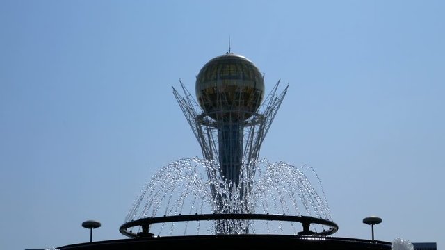 Kazakhstan, Nur-Sultan, the Bayterek tower and the fountain in the foreground. Sunny day, summer.