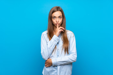 Young woman over isolated blue background showing a sign of silence gesture putting finger in mouth