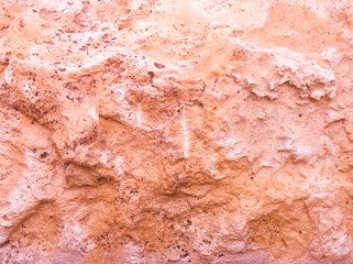 Naklejka premium The wall of the building. Pink texture of the stone.