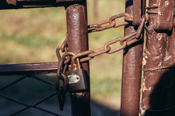 padlock locked on rustic door with chain outdoors
