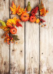 Festive autumn decor from pumpkins, berries and leaves on a rustic wooden background. Concept of...