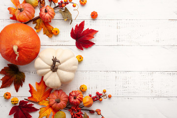 Festive autumn decor from pumpkins, berries and leaves on a white  wooden background. Concept of...