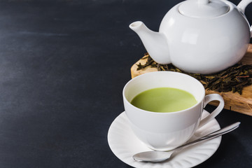 a cup of green tea on black table